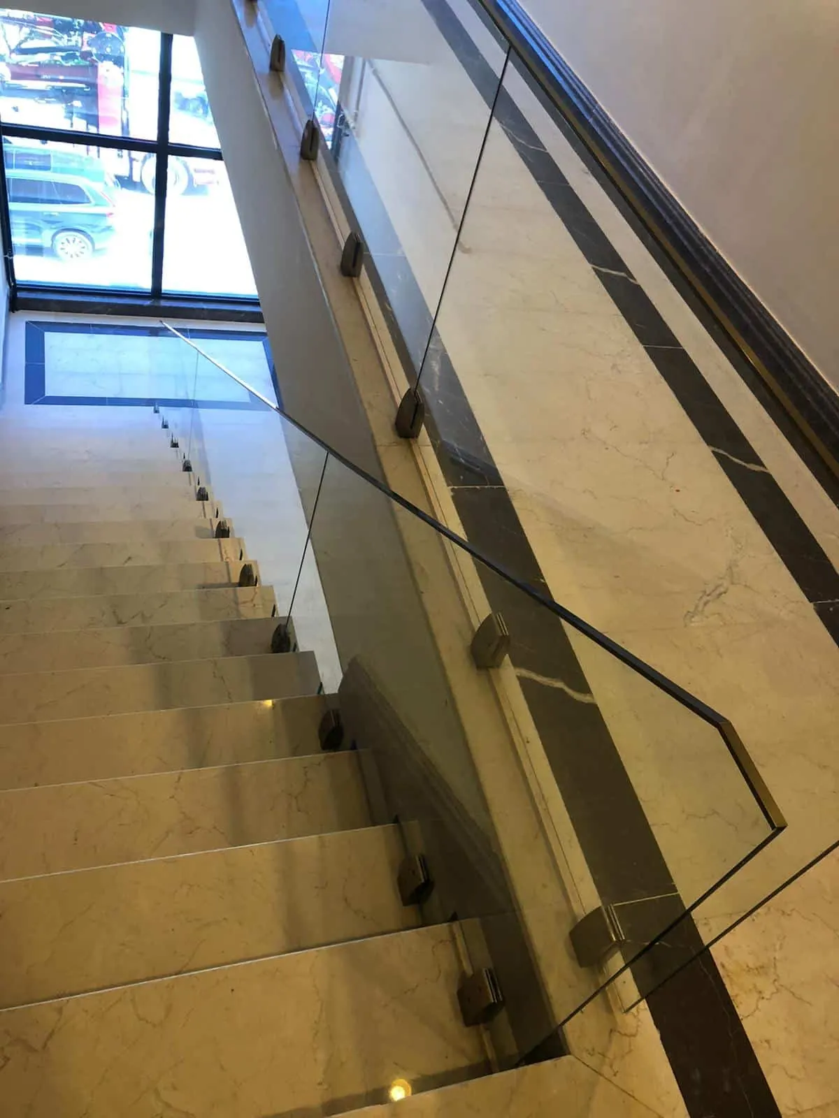Escalera interior con barandilla de vidrio laminado y pasamanos de acero